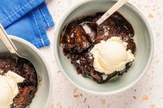 two bowls filled with ice cream and brownies on top of a white tablecloth