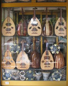 a display case filled with lots of different types of musical instruments in glass front window