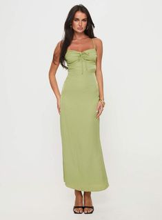 a woman in a green dress posing for the camera with her hands on her hips