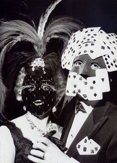 an old photo of two people dressed up as playing card suits and wearing headgear