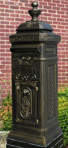 an old fashioned mailbox in front of a brick wall