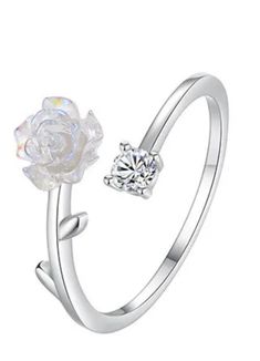 Experience the delicate beauty of the Rosea Ring. Made with white gold and sterling silver 925, this adjustable rose ring sparkles with zircon accents. A perfect addition to any outfit, the Rosea Ring is a timeless piece that exudes elegance and sophistication. Elevate your style with this stunning accessory. The Rosea ring is a size N before being adjusted 1-2 sizes on average, to ensure display is per photo. Materials: Sterling Silver 925, White Gold, Zircons Delicate Beauty, Sparkling Rings, Rose Ring, Timeless Pieces, Silver 925, Sparkle, White Gold, 925 Sterling Silver, Sterling Silver