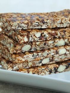 three granola bars stacked on top of each other in front of a white plate