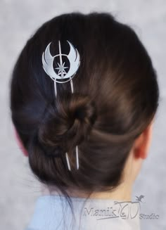 a woman with her hair in a bun is wearing a star wars inspired head piece