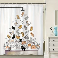 a shower curtain with cats on it in front of a white cabinet and dresser next to the bathtub