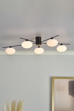 an image of a ceiling light fixture in the living room or dining room with art on the wall