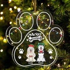 a glass ornament with a dog's paw and name on it hanging from a christmas tree