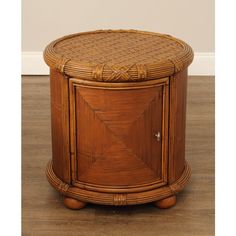 a round wooden table with wicker on the top and bottom, sitting on a hard wood floor