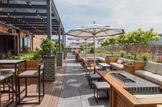 an outdoor patio with tables, chairs and umbrellas on the roof top terrace area