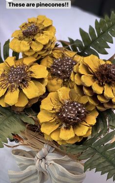 yellow flowers are in a vase with green leaves on the side and an ad that says, these are pinecones