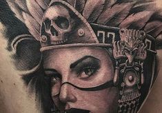 a woman's back with a skull and headdress tattoo on her chest