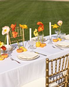 the table is set with flowers and candles for an outdoor wedding reception or special event