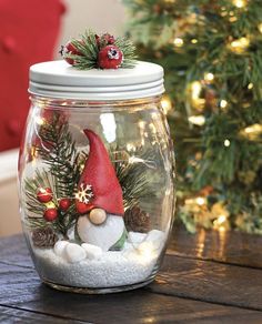 a glass jar filled with snow and christmas decorations