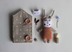 a stuffed animal is next to a knitted doll and buttonholes on a white surface