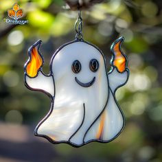 a stained glass ghost hanging from a tree