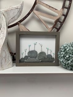 a white shelf with some rocks and flowers on it