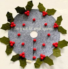 a felt christmas tree skirt with holly leaves and red berries