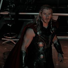 thor is standing in the dark with his cape open