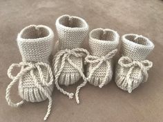 four crocheted baby booties are sitting on the floor