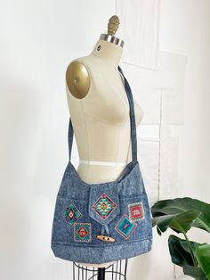 Vintage 80's bag. Denim fabric in a great blue shade. Southwestern appliqués are detailed with shimmery glitter. Flap closure with single, wooden button closure. Two, interior pockets and two exterior pockets. ---------------------------- details circa | 1980's material | denim ---------------------------- measurements length | 15 inches width | 12 inches strap drop | 18 inches ---------------------------- condition very good Vintage Blue Denim Shoulder Bag, Embroidered Denim Bags For Everyday Use, Blue Embroidered Denim Bags, Blue Bohemian Bag With Pockets, Blue Bohemian Bags With Pockets, 60s Glam, Denim Applique, Envelope Clutch Purse, Carpet Bag