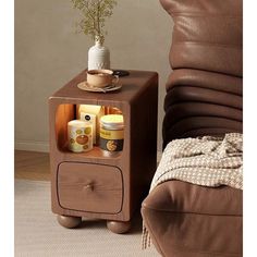 a brown leather chair and table with a potted plant on it next to a couch