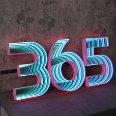 a neon sign that reads 360 on it's side next to a concrete wall