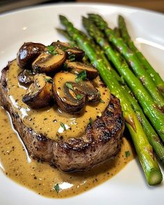 steak with mushrooms and asparagus on a white plate