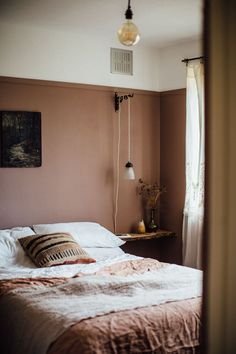 a bed sitting in a bedroom next to a window