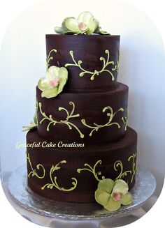 a three tiered chocolate cake with flowers on top