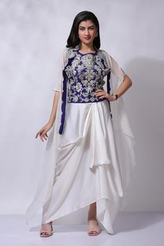 Blue and white embroidered asymmetric long cape. Paired with an embroidered inner and pant.
Components: 3
Pattern: Embroidered
Type Of Work: Hand embroidery
Neckline: Round
Sleeve Type: Asymmetric
Fabric: Silk
Color: Blue,White
Other Details: 
Attached cotton lining
Model Height: 5 ft 7 inches, wearing size M
Closure: Button
Occasion: Mehendi and Haldi - Aza Fashions Blue Hand Embroidery, Cape Skirt, Embroidery Neckline, Long Cape, Designer Dresses Casual, Fabric Silk, Blue Silk, Embroidered Silk, Aza Fashion