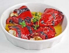 a white bowl filled with cooked lobsters covered in sauce and garnished with parsley