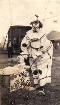 an old photo of a clown pushing a baby in a wagon with a sign on it