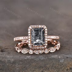 an engagement ring set with a fancy black and white diamond in the center, on top of a rock