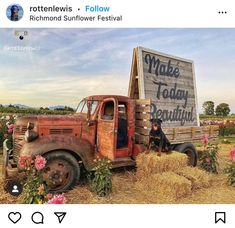 an old truck is sitting in the middle of a field full of flowers and hay