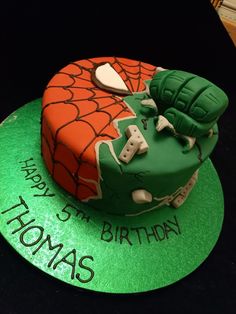 a spiderman birthday cake with green and orange frosting