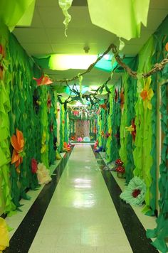 a hallway decorated with paper flowers and streamers on the ceiling is lit by green lights