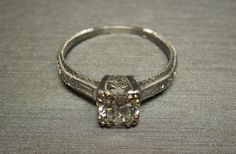 an antique style diamond ring with filigree accents