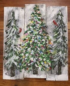 three pieces of wood painted with christmas trees and cardinals on the snow covered ground