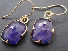 Introducing a beautiful and unique pair of Blue Tanzanite Dangle Earrings, handcrafted by the talented artisan Angeline using the traditional lost wax process. These stunning earrings are the perfect way to add a touch of elegance and sophistication to any outfit. Each earring features a breathtaking 12.5mm x 9.5mm blue Tanzanite gemstone, selected for its stunning color and quality. The Tanzanite is suspended from a delicate 14K gold wire, creating a graceful dangle style that will add a touch Blue Tanzanite, Tanzanite Gemstone, Minerals And Gemstones, Lost Wax, Stunning Earrings, Gold Wire, Crystals Minerals, Jewelry Collection, Dangle Earrings