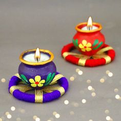 two colorful candles sitting next to each other on top of a gray surface with white dots