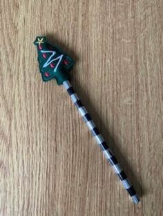 a toothbrush with a christmas tree on it sitting on top of a wooden table