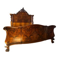 an ornate wooden bed frame with carvings on it