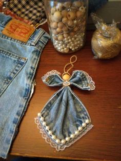 a pair of jean pants and some other items are on a table next to a jar full of beads