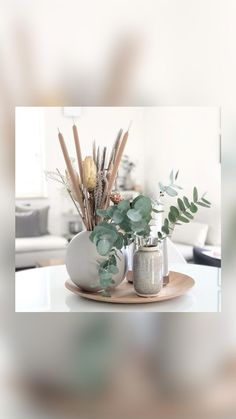 there is a vase with plants in it on the table next to two salt and pepper shakers