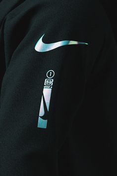 the back of a black nike sweatshirt with a silver nike logo on it's chest