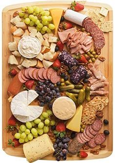 a wooden platter filled with different types of cheese and meats