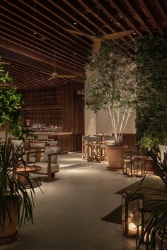 the interior of a restaurant with tables, chairs and candles lit up in front of them