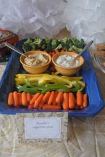 carrots, broccoli, and other vegetables on a blue tray with a name tag