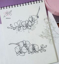 two drawings of flowers on top of a table next to a pink bowl and pen