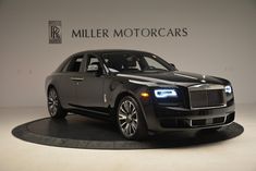 a black rolls royce parked in front of a miller motorcars logo on the wall